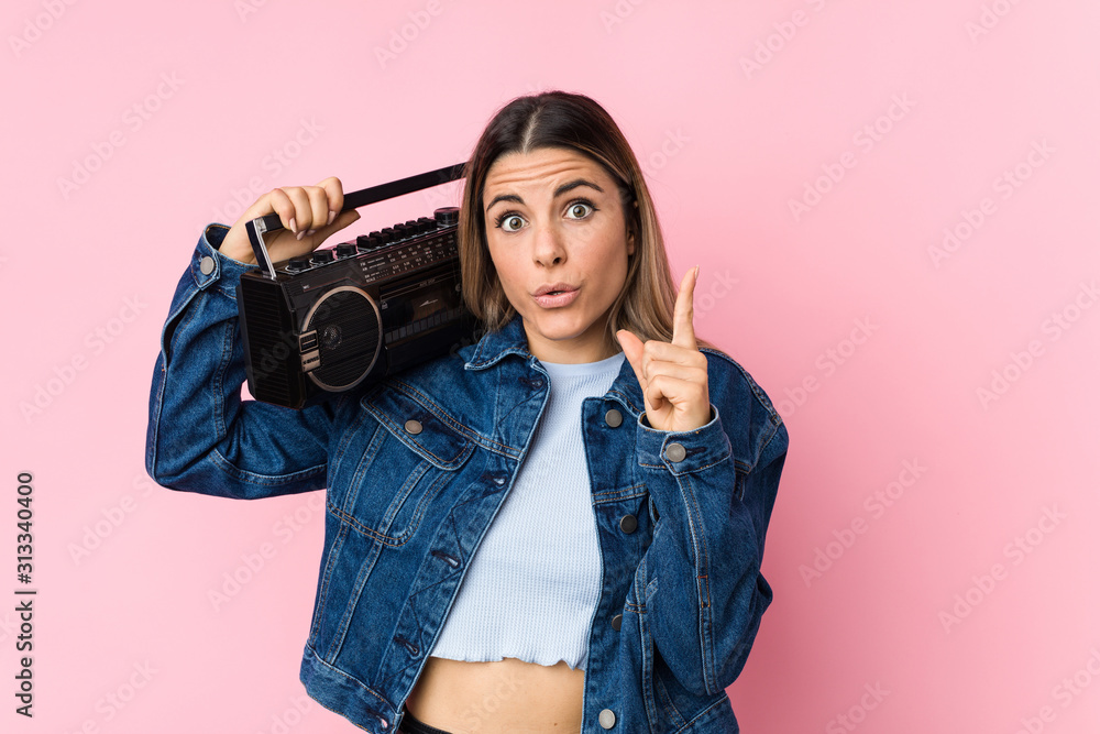 Young caucasian woman holding a guetto blaster having some great idea, concept of creativity. Young caucasian woman holding a guetto blaster having some great idea, concept of creativity.