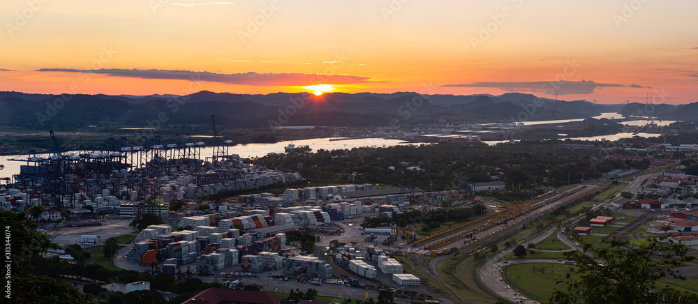 Container ships passing through Panama canal in scenic landscape at sunset