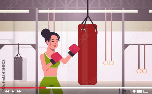 woman blogger hitting huge punching bag sportswoman boxer vlogger recording online video for blog healthy lifestyle live streaming concept modern boxing studio interior horizontal portrait vector