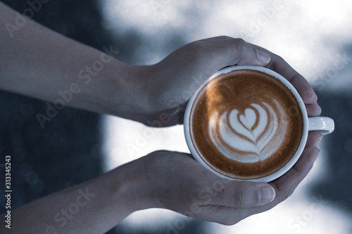 Top view woman hands holding cup of coffee. Latte art, Cup Mug, Cool light colour. 