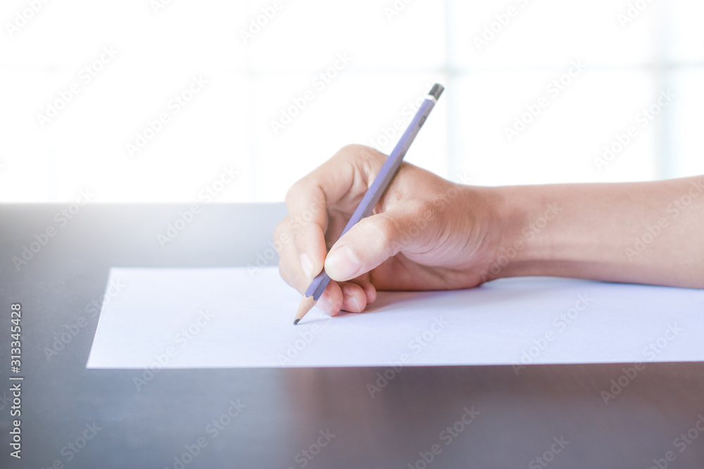 Hand with pencil and blank paper isolated on white background. The person who is sketching Hand with pencil and blank paper isolated on white background. The person who is sketching