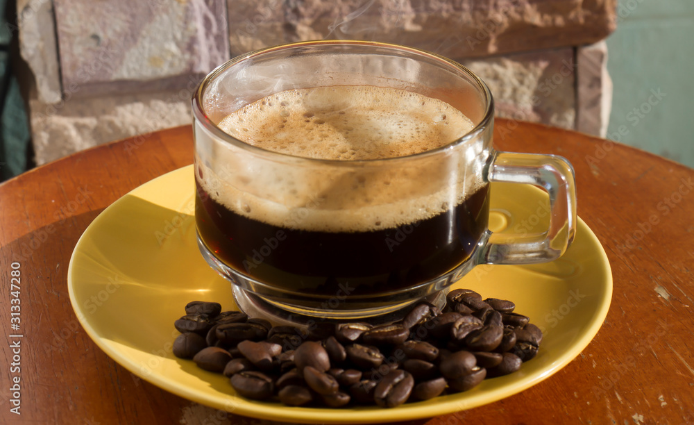 Clear coffee cups and beans on a wooden table in the morning natural light Clear coffee cups and beans on a wooden table in the morning natural light