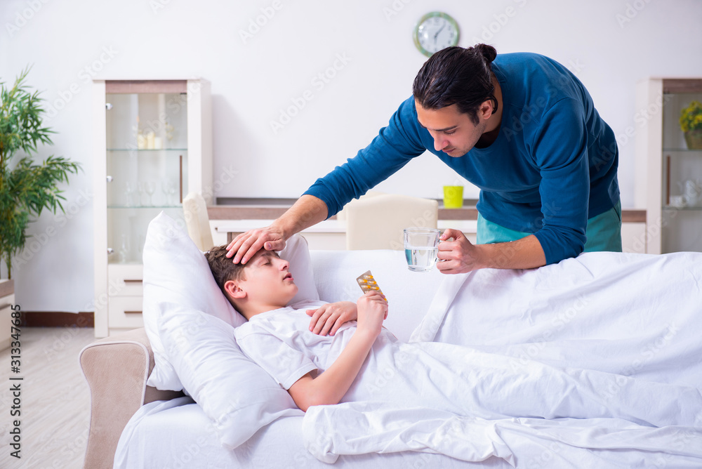 Fototapeta premium Young father caring for sick son