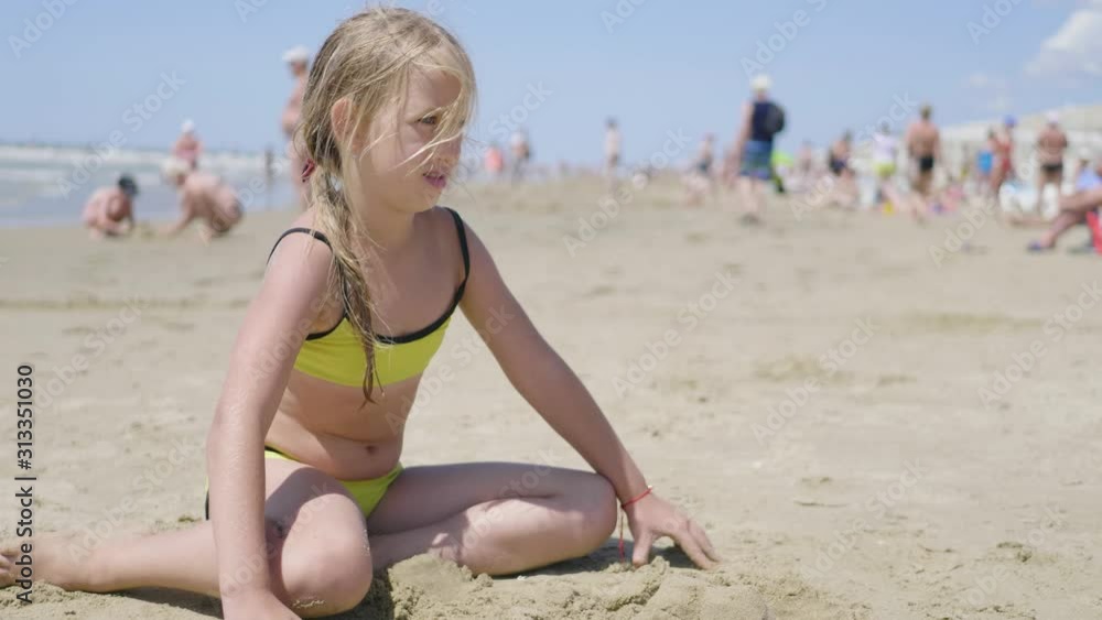 Little girl playing with sand on beach. Enjoying a lovely vacation. Little girl playing with sand on beach. Enjoying a lovely vacation.