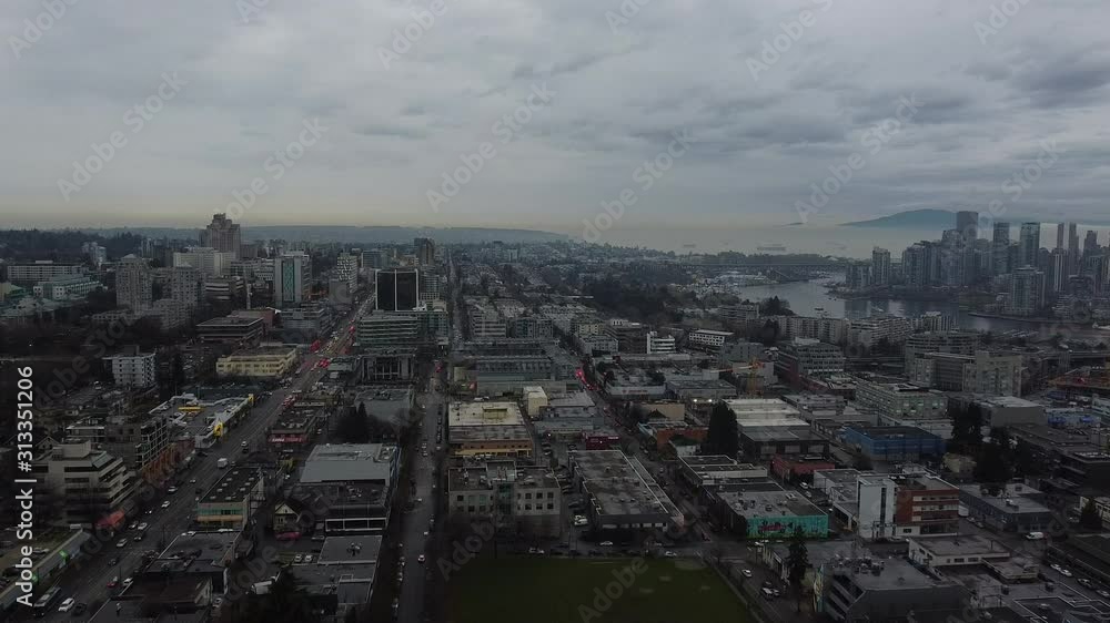 Fly over Vancouver roofs with Broadway traffic and partially visible downtown Fly over Vancouver roofs with Broadway traffic and partially visible downtown