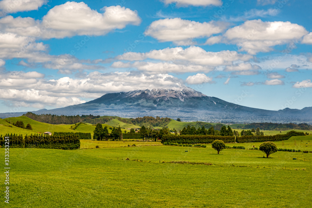 Cloud covered volcanic Mount Egmont in the agricultural farming Taranaki countryside