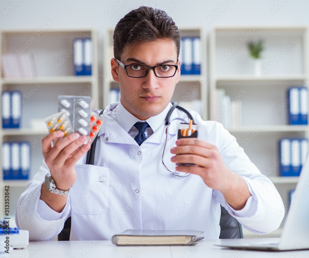 Male doctor in anti-smoking conceptwithcigarette pack Male doctor in anti-smoking conceptwithcigarette pack