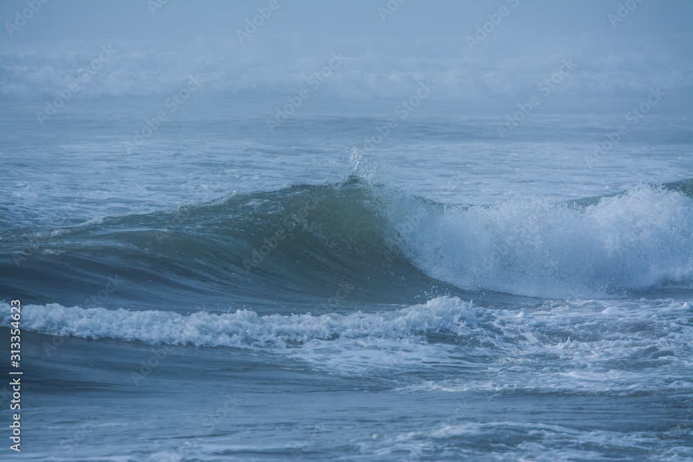 Massive waves crashing in ocean .
