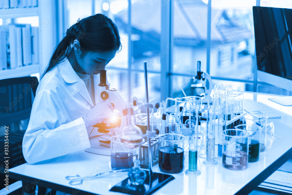 Fototapeta premium Asian woman scientist with microscope and science experiment equipment in laboratory, Scientific research.