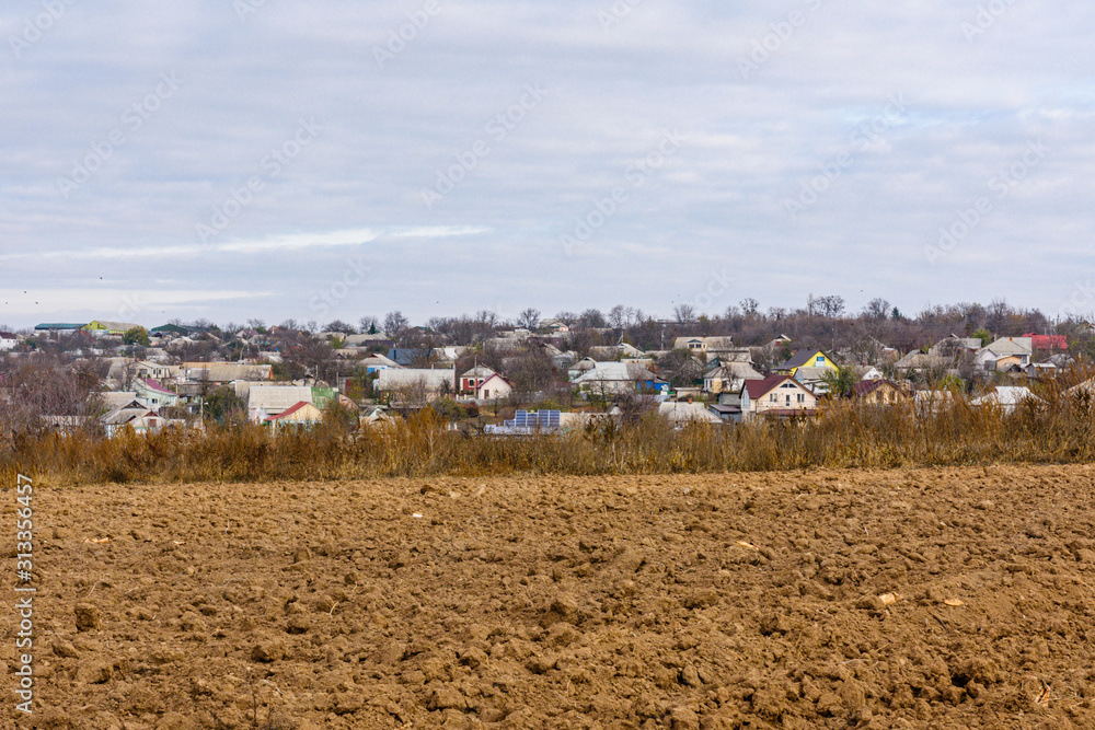 Plowed field at autumn. City Uman on a background. Ukraine