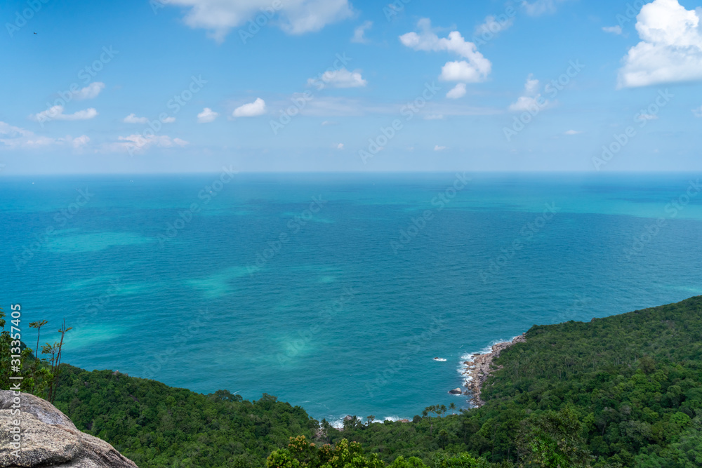Beautiful stunning vibrant landscape, blue sea and sky with white clouds, aerial view of the sea and green jungle