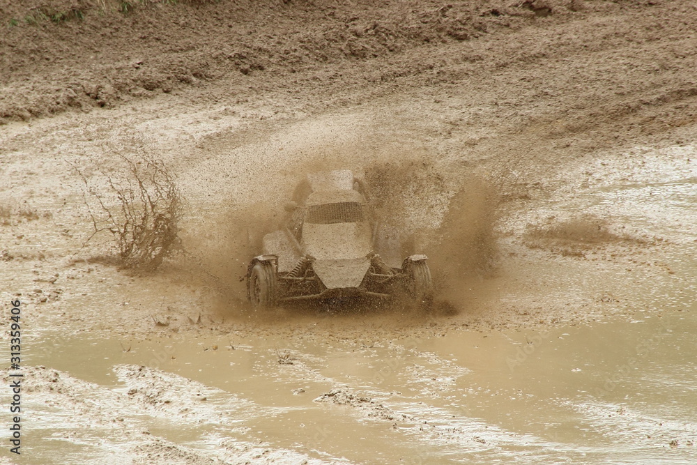 Obraz premium Speed one Buggy car in muddy puddle dirt splash on off road track race turn, front view