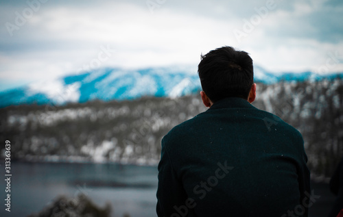 fashionable man sits on edge overlooking beautiful lake © TIMOTHY