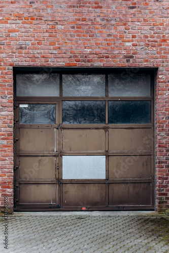 Large garage door with brick wall and asphalt driveway