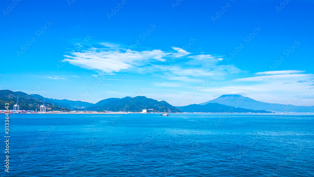 Landscape view of Fuji Mountain over blue sky and white cloud from the ferry boat in the ocean at Suruga Bay, Shizuoka, Japan Landscape view of Fuji Mountain over blue sky and white cloud from the ferry boat in the ocean at Suruga Bay, Shizuoka, Japan