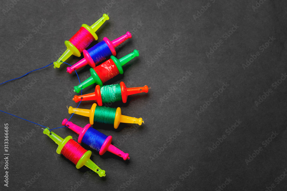 Spool with colourful thread or manjha or manja on dark background. Indian festival makar sankranti concept Spool with colourful thread or manjha or manja on dark background. Indian festival makar sankranti concept