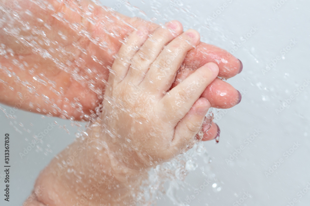 Care and cleanliness concept. Daily washing of the child. A small baby hand in the hands of the mother, close-up. Bathing for children Care and cleanliness concept. Daily washing of the child. A small baby hand in the hands of the mother, close-up. Bathing for children