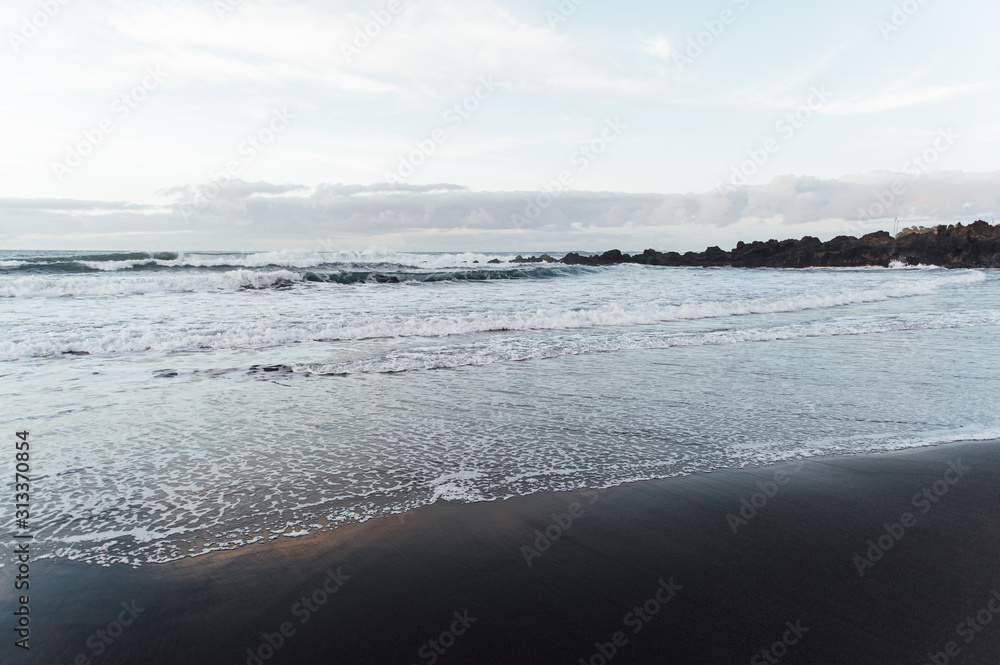 Fototapeta premium Fantastically beautiful sunset on the north coast of Tenerife, a beach with stones and black sand.