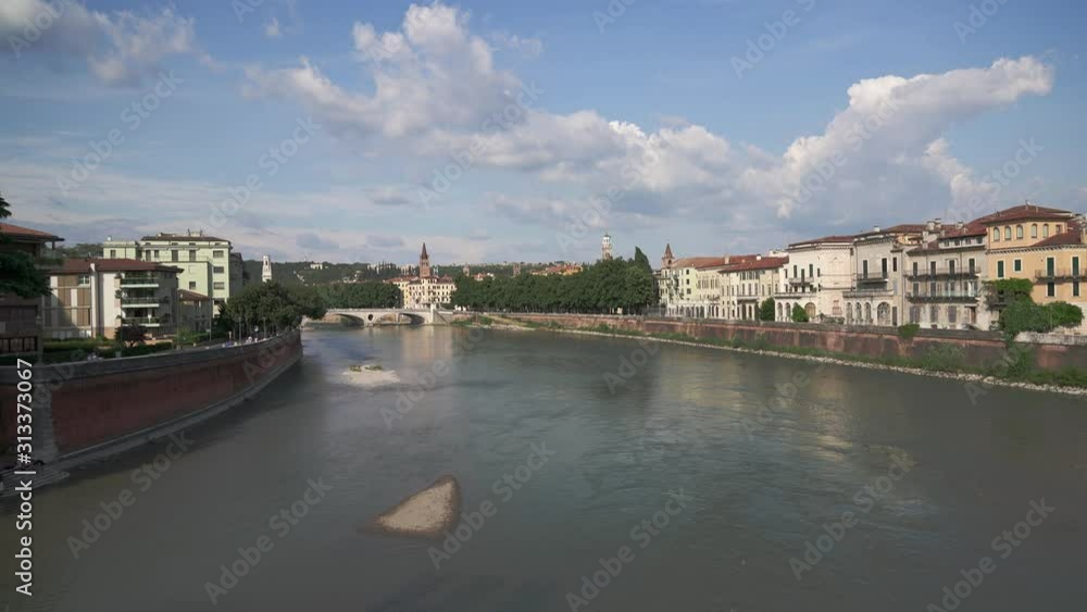 View of Bridge of the Victory in old city of Verona under blue cloudy sky in summer. Gimbal shot of view on Verona and the bridge View of Bridge of the Victory in old city of Verona under blue cloudy sky in summer. Gimbal shot of view on Verona and the bridge