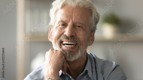 Portrait elderly man with candid wide smile looking at camera photo