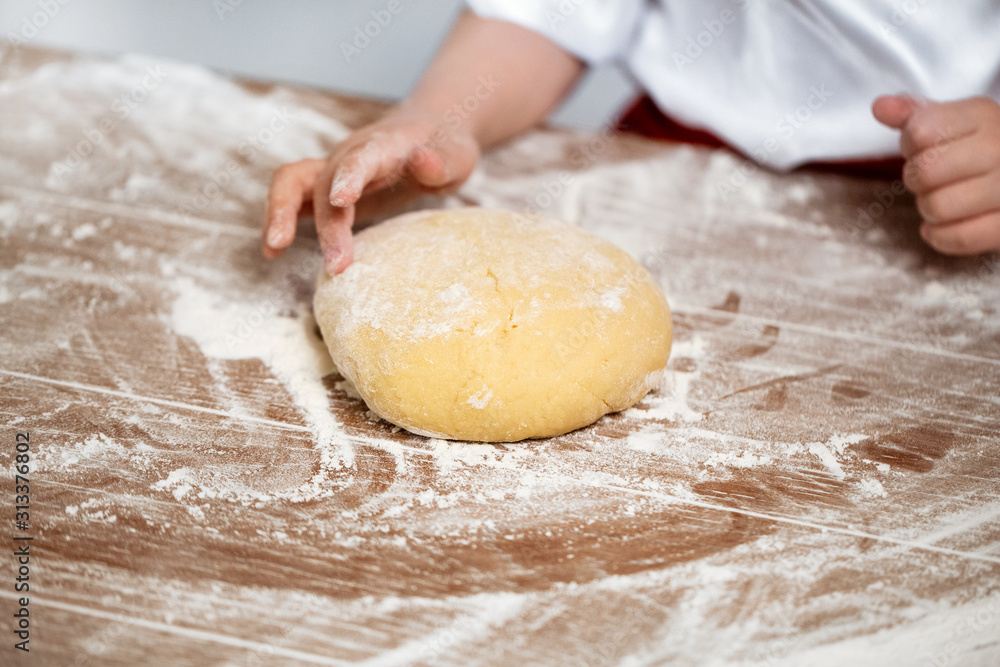 Hands of the child knead dough on a table Hands of the child knead dough on a table