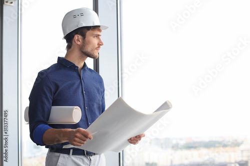 Shot of male architect wearing hardhat and inspecting new building.