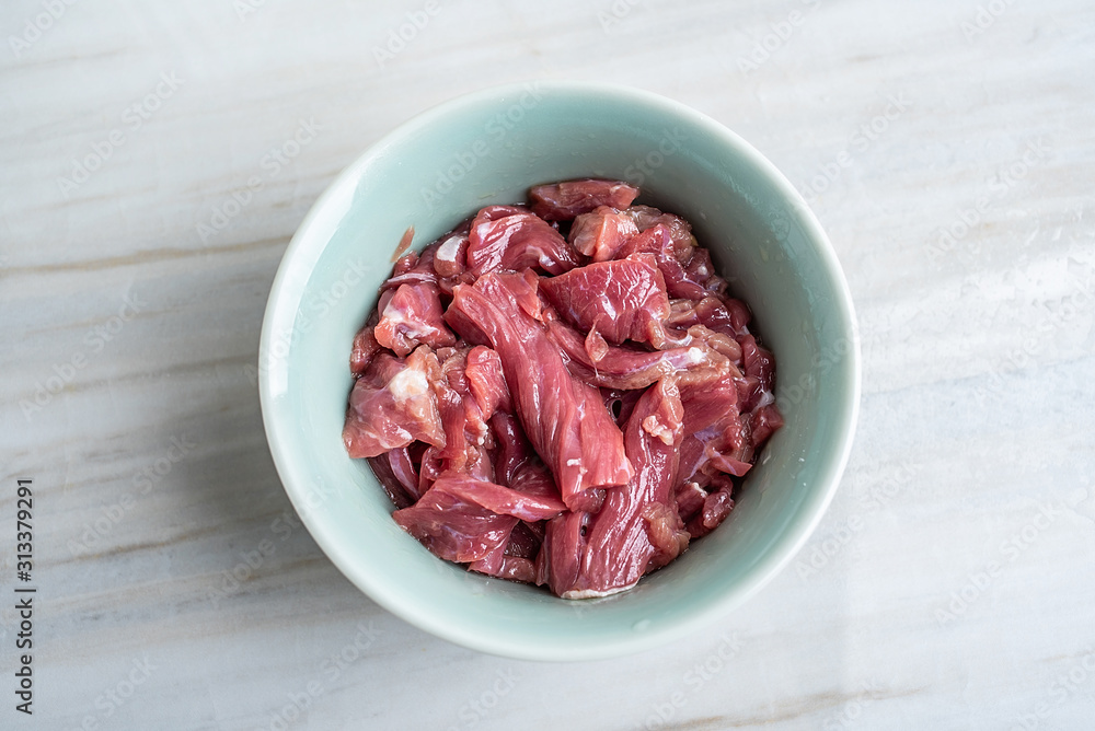 A bowl of cured beef on a kitchen tile countertop plate A bowl of cured beef on a kitchen tile countertop plate