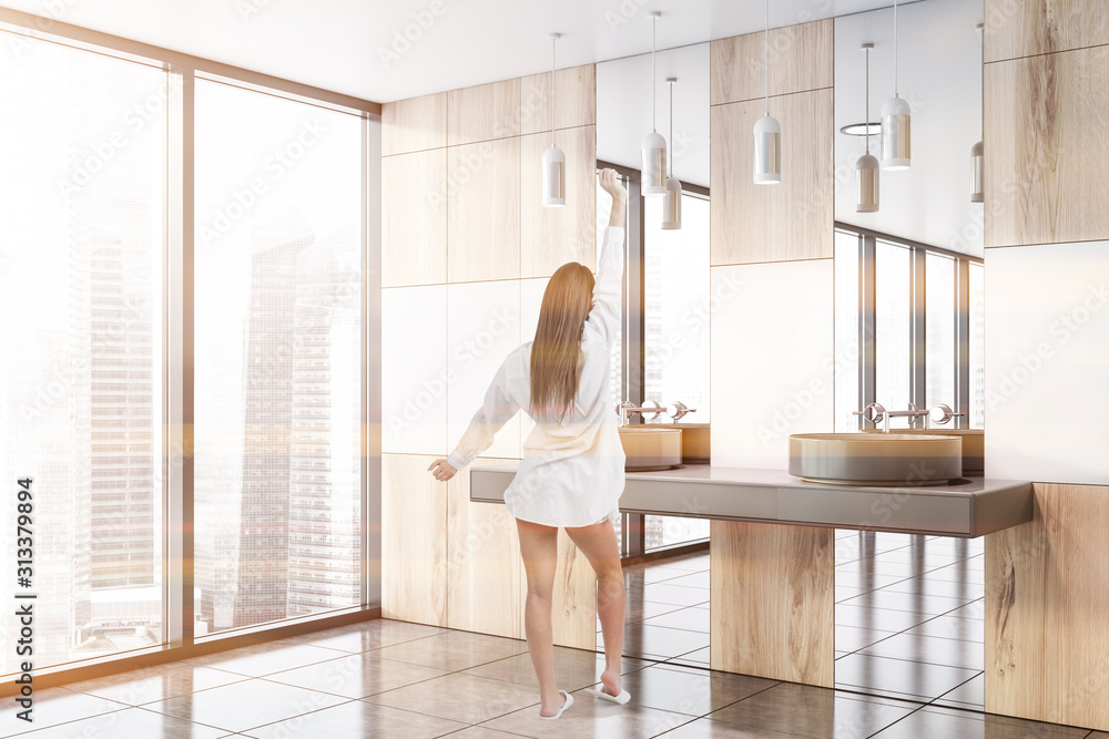 Woman in white and wood bathroom with sink Woman in white and wood bathroom with sink