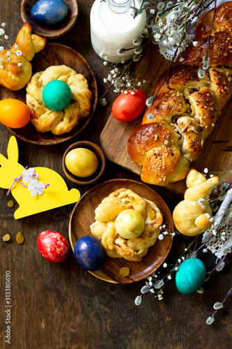 Easter holiday table. Easter cakes and colored eggs on a wooden table. Top view flat lay background. Copy space.