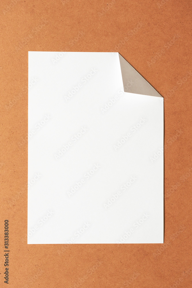 White empty clean paper sheet with folded corner on cardboard background. Top view, vertical. Template for poster. Mockup placard White empty clean paper sheet with folded corner on cardboard background. Top view, vertical. Template for poster. Mockup placard