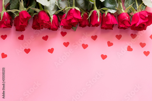 Fototapeta Naklejka Na Ścianę i Meble -  Border of red roses and hearts on a pink background - valentines day concept