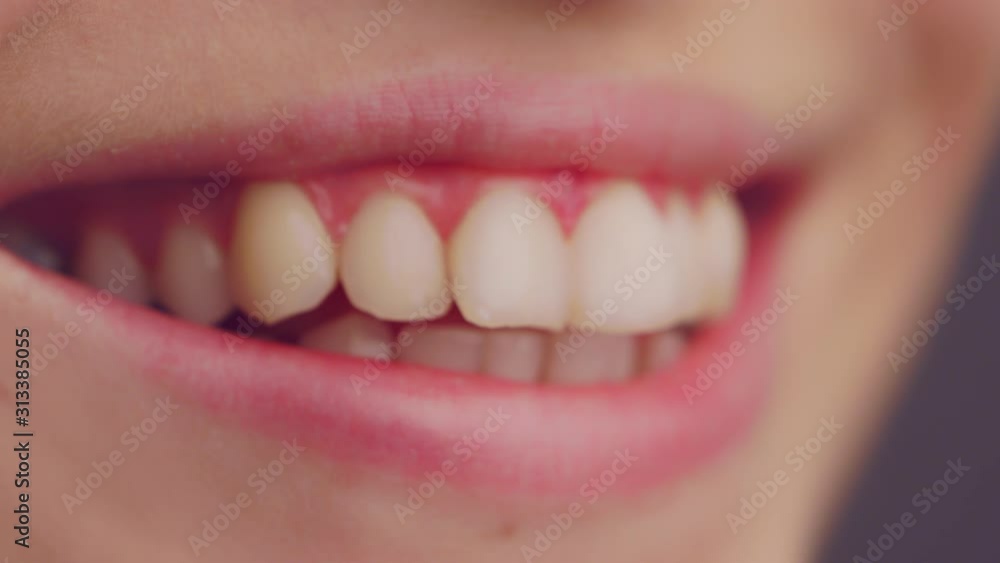 extreme close up of a woman's mouth. Smiling and revealing healthy white teeth. Selective focus with shallow depth of field extreme close up of a woman's mouth. Smiling and revealing healthy white teeth. Selective focus with shallow depth of field