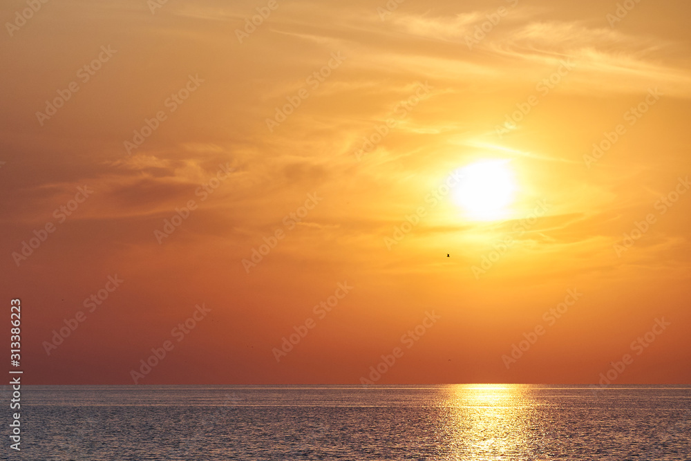 Yellow orange Sunset on sea or ocean, beach coast. Alone man on sunset beach on land.