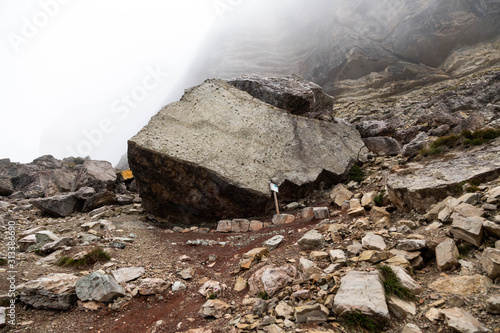 A giant rock with dinosaurs footprints at the foot of Mount Pelmo in The Dolomites, dating back 200 million years ago. There are captured footprints at least three different dinosaur species. Italy.  photo