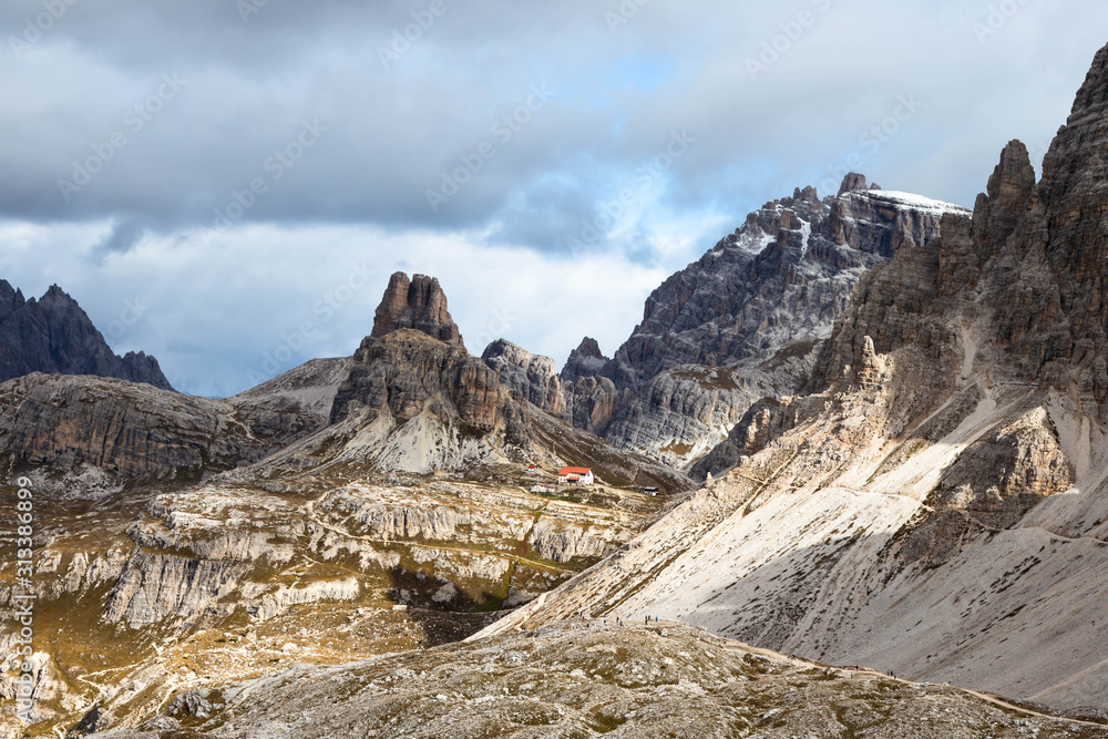 Mountain landcape: a tiny mountain hut in the Dolomites and a hiking trail to it, National Park Tre Cime di Lavaredo, also know as Drei Zinnen or Three Peaks of Lavaredo. Italy, South Tyrol. 