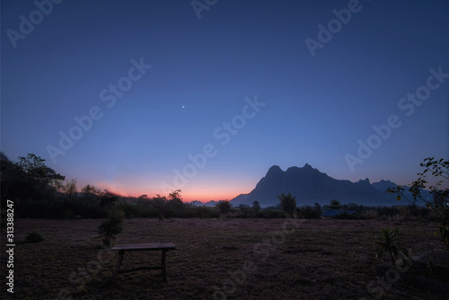 wonderful and beautiful sky between foggy mountains before sunrise in front with empthy chair