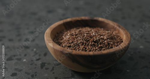 flaxseed in olive bowl on terrazzo countertop with copy space