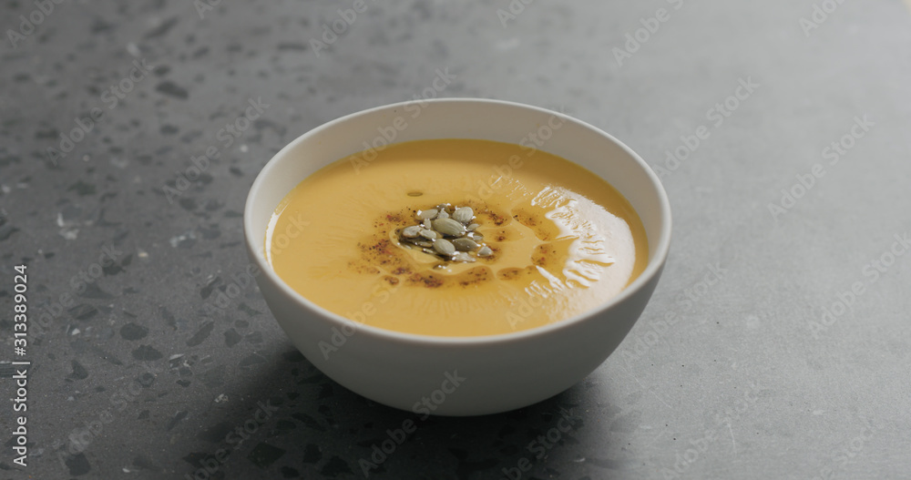 pumpkin cream soup in white bowl on terrazzo countertop pumpkin cream soup in white bowl on terrazzo countertop