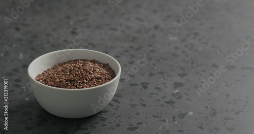 flaxseed in white bowl on terrazzo countertop with copy space