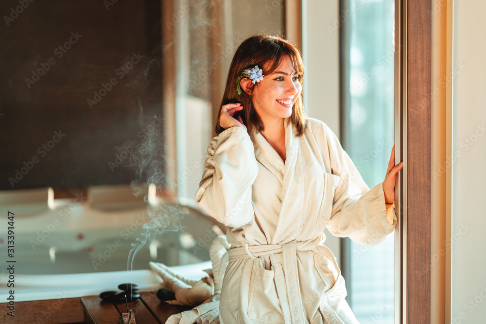 beautiful woman is looking out from window while waiting for massage at spa center. beautiful woman is looking out from window while waiting for massage at spa center.