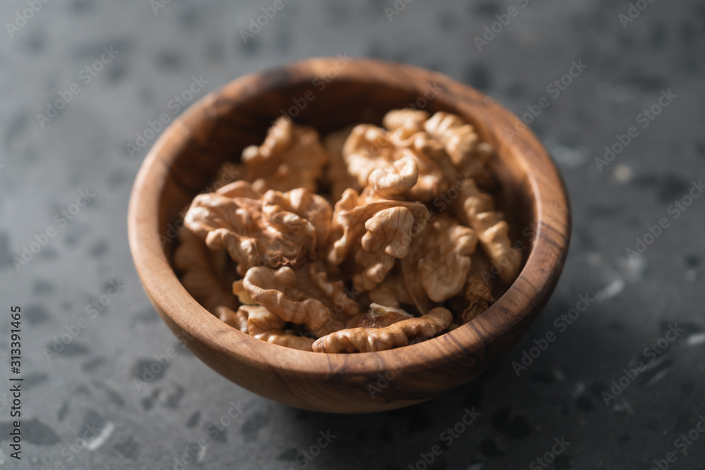 Walnuts in wooden bowl on terrazzo countertop Walnuts in wooden bowl on terrazzo countertop