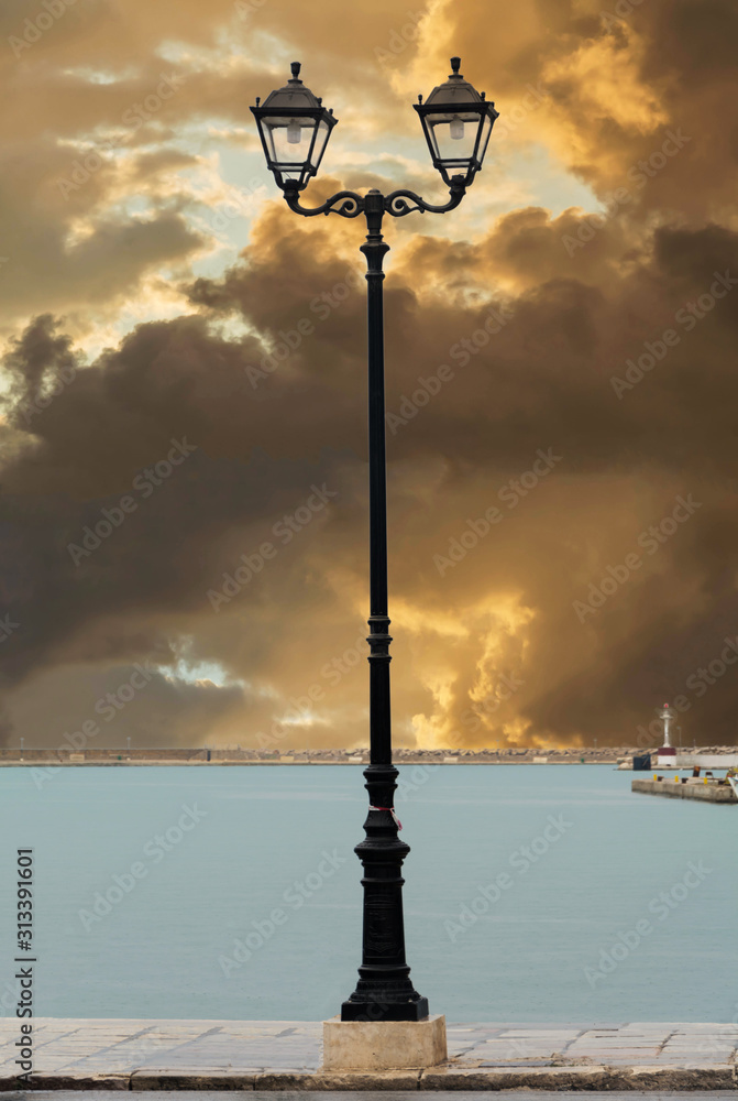 Street lamp of Zakynthos harbor Greece. Street lamp against dramatic sunset.