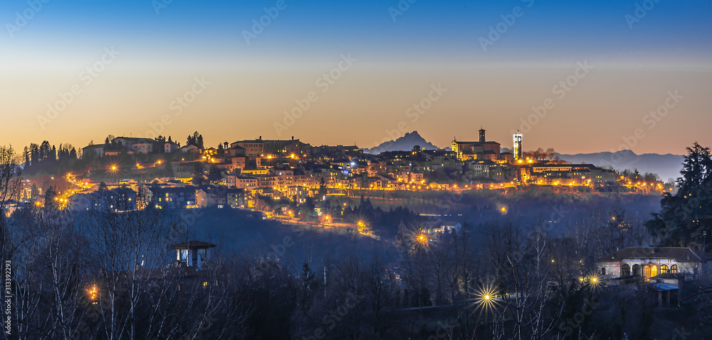 La città alta di Mondovì al crepuscolo, con alle spalle l'inconfondibile sagoma del Monviso