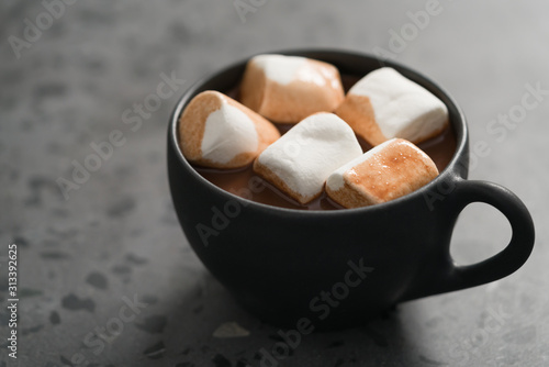 cup of hot cocoa with marshmallow on terrazzo background