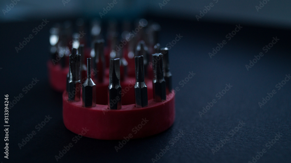 A set of small screwdrivers on a black background. Focus in the foreground. A set of small screwdrivers on a black background. Focus in the foreground.