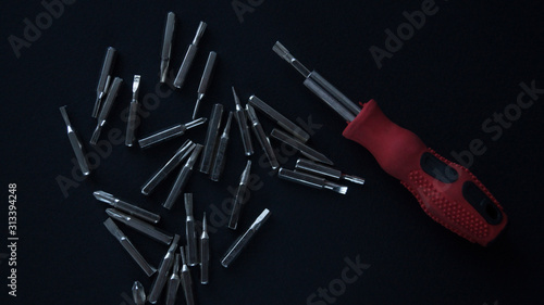 A small screwdriver with an additional set of nozzles on a black background.