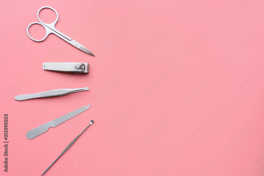 Set of manicure instruments and tools on pink background, top view, copy space Set of manicure instruments and tools on pink background, top view, copy space
