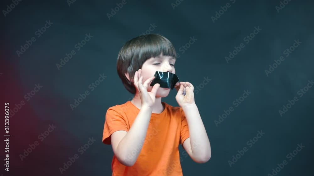 A boy with a sealed mouth screams around, an expression of children protest. A boy with a sealed mouth screams around, an expression of children protest.