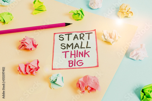 Word writing text Start Small Think Big. Business photo showcasing Initiate with few things have something great in mind Colored crumpled papers empty reminder blue yellow background clothespin © Artur