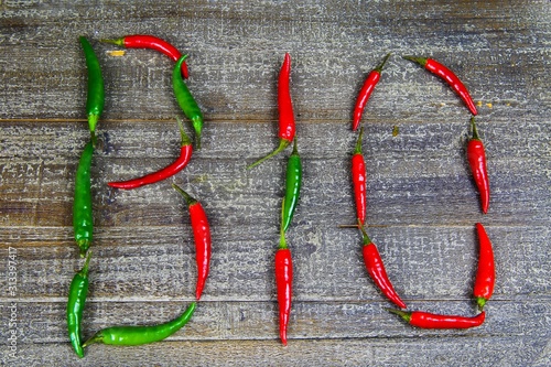 Organic healthy food symbol concept: Red and green Chillies forming the word bio on old wood table